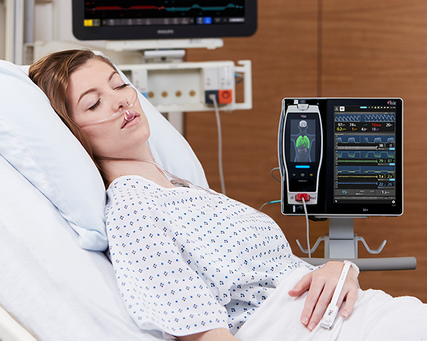 Patient mit Kanüle, neben dem ein Root-Monitor Kapnographieparameter anzeigt
