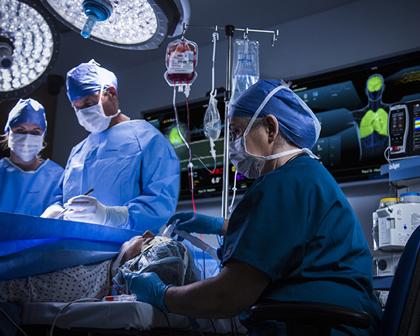 Ärzte operieren an einem Patienten mit UniView im Hintergrund des Operationssaals