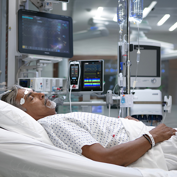 Patient im Krankenhaus, der Masimo-Monitore und -Sensoren zur kontinuierlichen Vitalzeichen- und Gehirnfunktionsüberwachung verwendet.